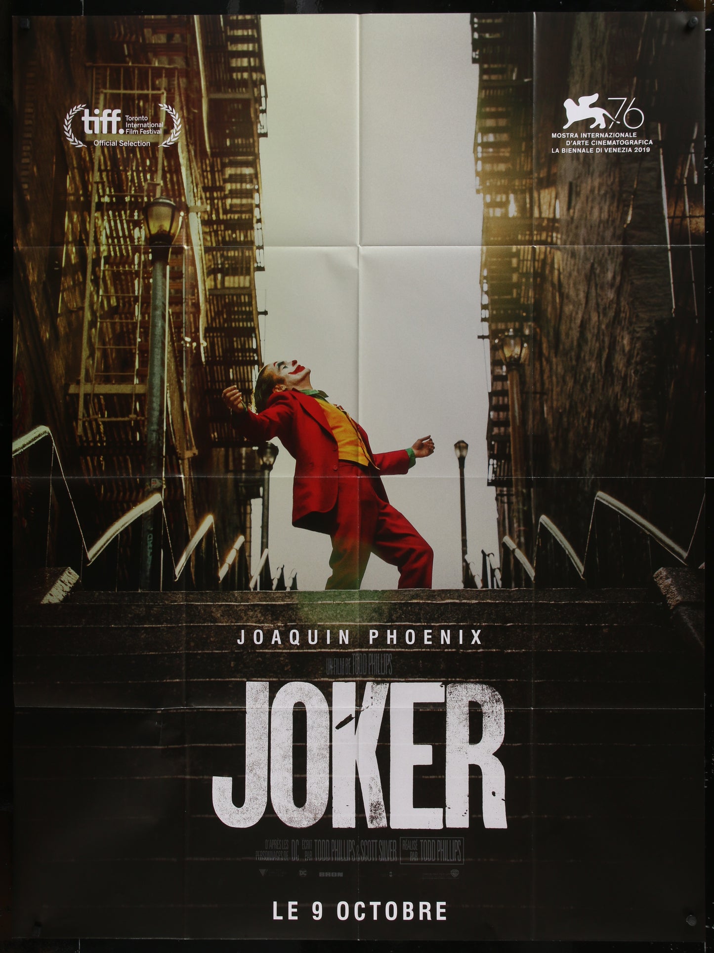 Movie poster for 'Joker' featuring Joaquin Phoenix in a red suit against a cityscape.