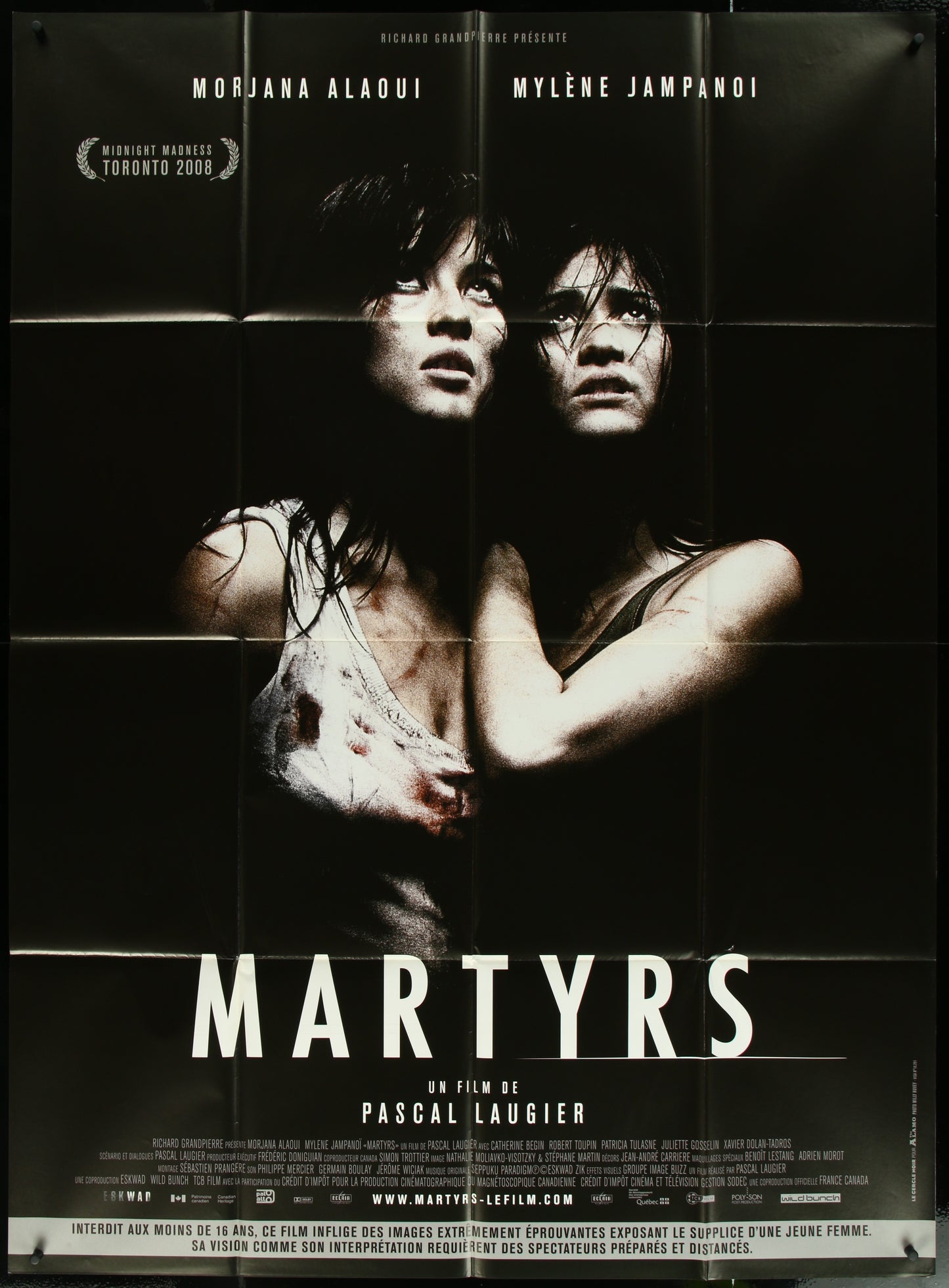 French one-panel movie poster for 'Martyrs' featuring two female characters in a dramatic pose against a dark background.