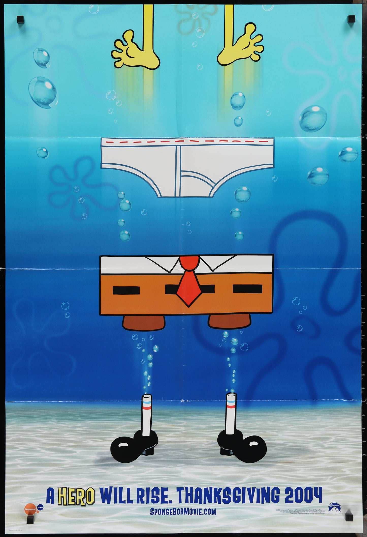 The image features a vibrant and colorful movie poster for the 2004 animated film "The SpongeBob SquarePants Movie." The poster depicts the iconic character SpongeBob SquarePants in a humorous and playful pose, with a backdrop of a blue ocean.