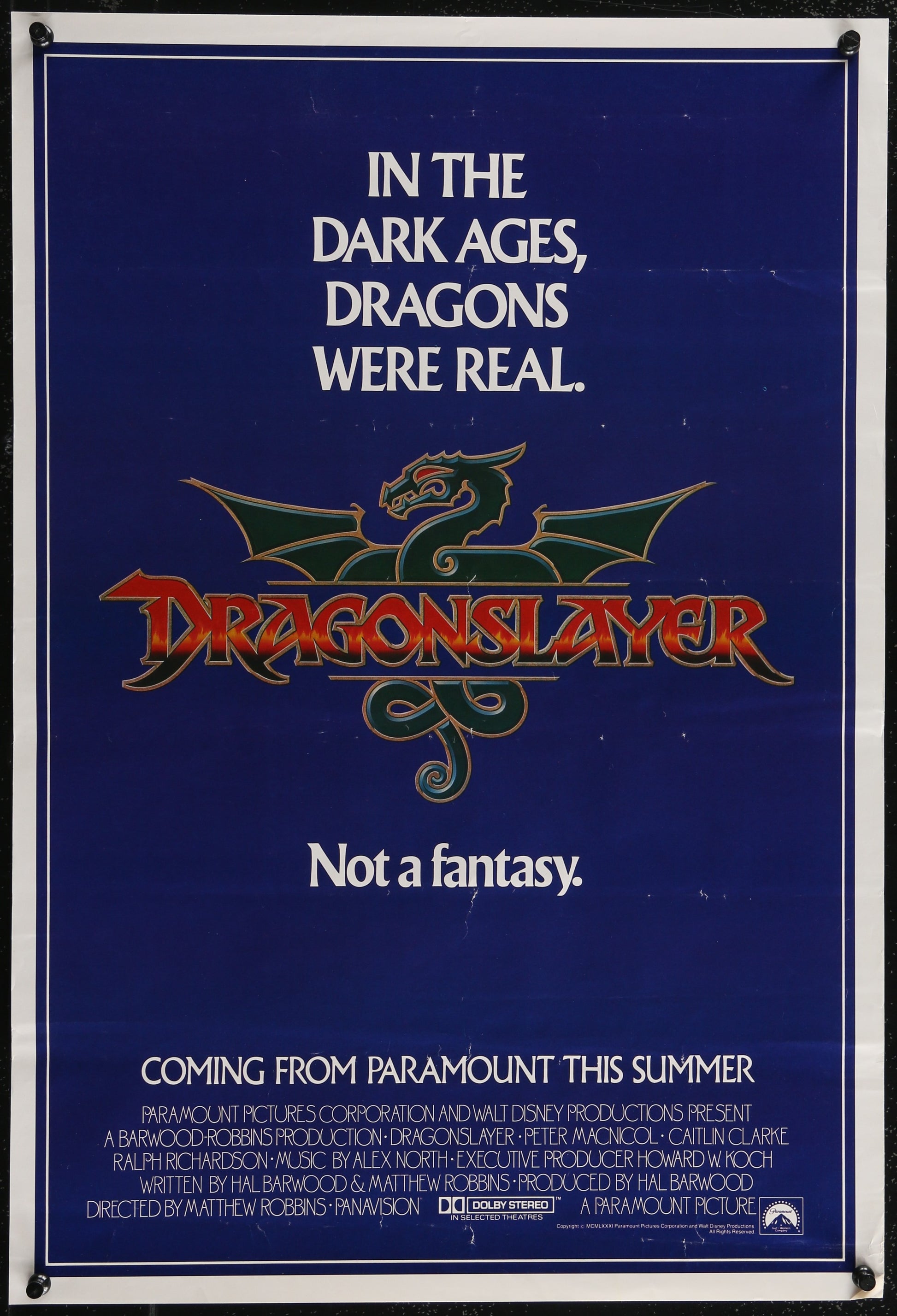 Vintage movie poster for 'Dragonslayer' featuring a green dragon design and the text of the movie title along with a quote.