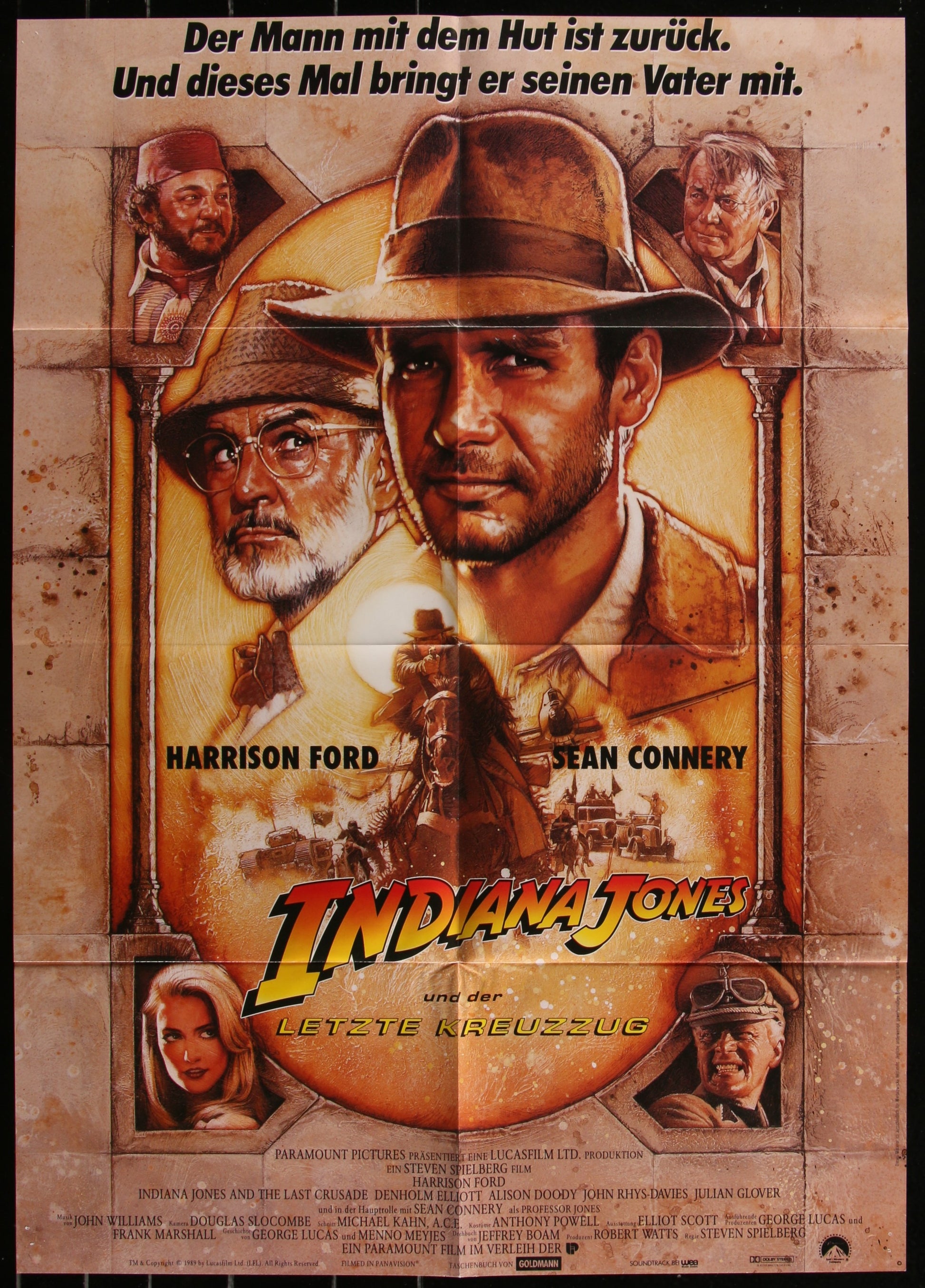 A vintage German movie poster for 'Indiana Jones And The Last Crusade' featuring Harrison Ford and Sean Connery with a yellowish tint and a shadow of a hat-wearing character in the foreground.
