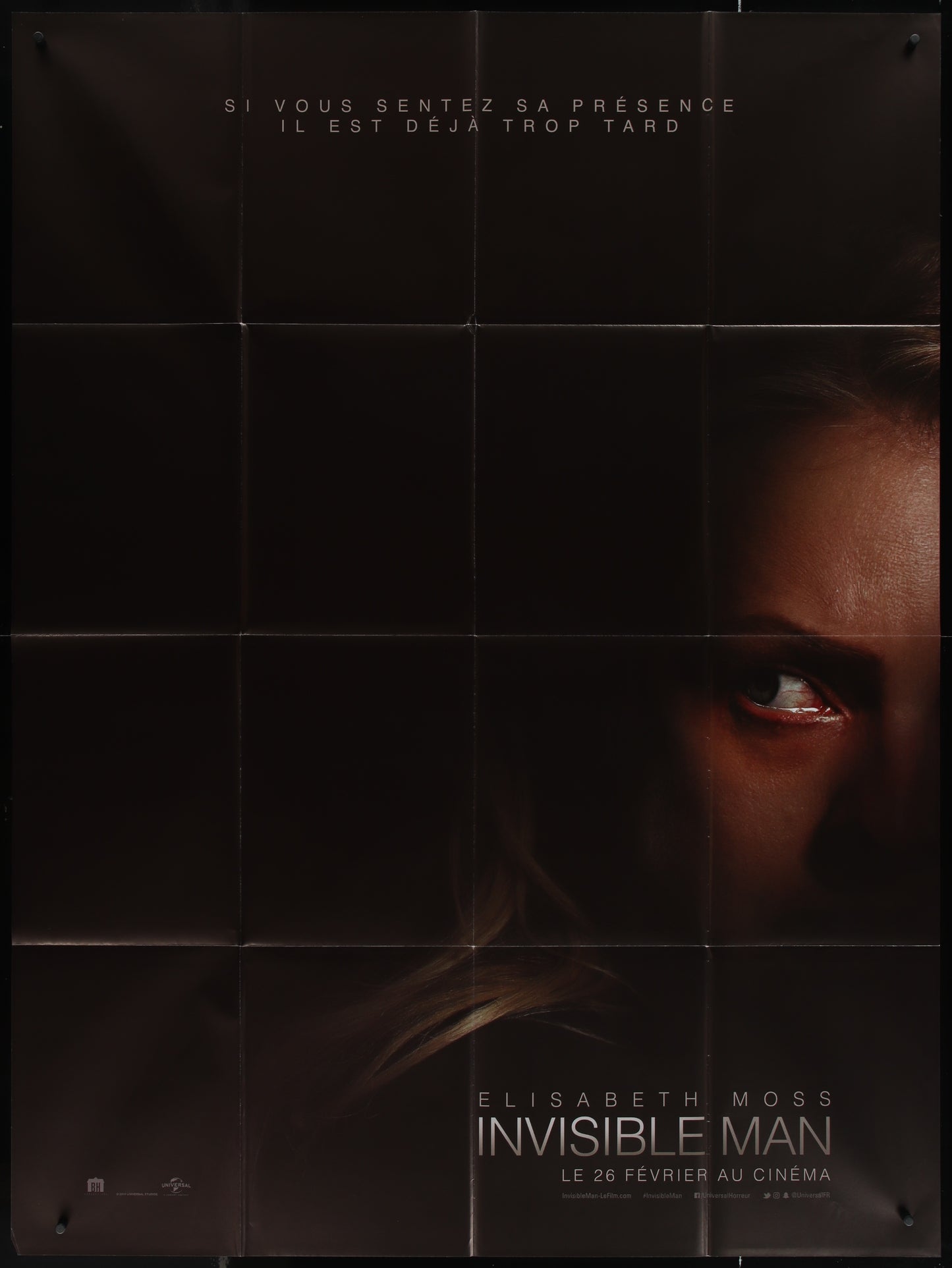 A poster of the movie 'The Invisible Man' featuring a close-up image of an actress, likely Elisabeth Moss, with a dramatic expression. The poster is predominantly black with white and red text.