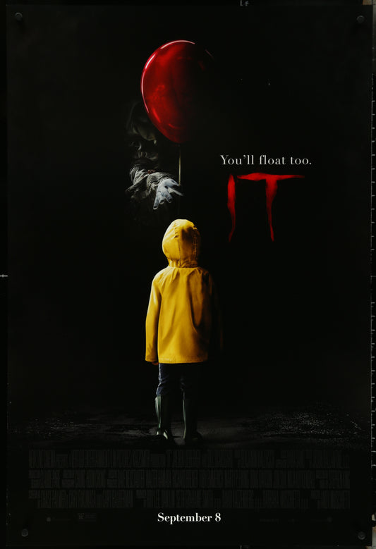 Original US one-sheet movie poster for It (2017) featuring a young boy in a yellow raincoat with a large red balloon, and a menacing clown figure in the background.