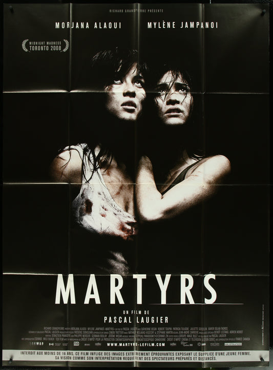 French one-panel movie poster for 'Martyrs' featuring two female characters in a dramatic pose against a dark background.