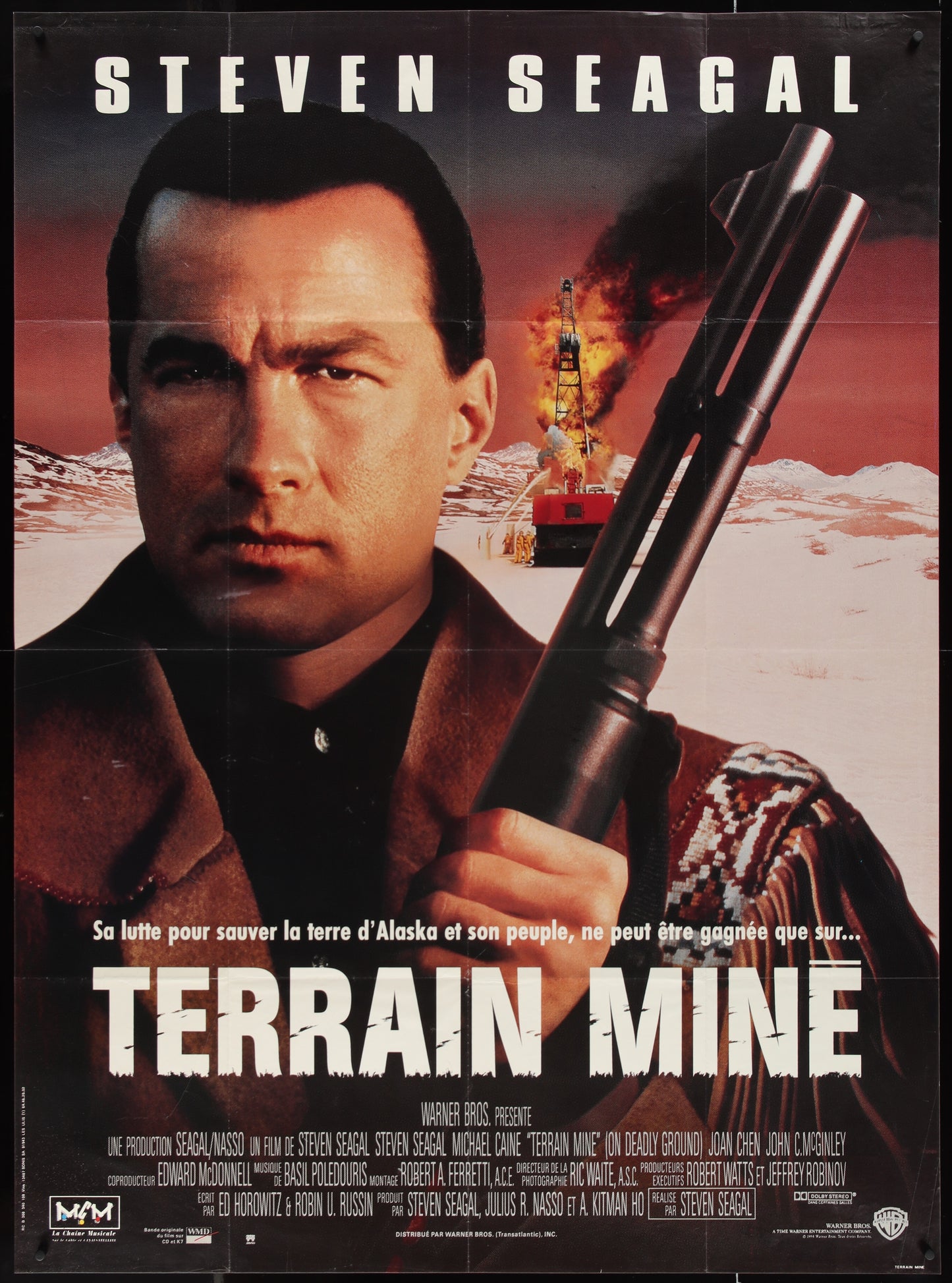 A vintage movie poster featuring a man with a gun, presumably the main character, in a dramatic landscape with a boat and mountains in the background, indicating an Alaskan setting for the film 'Terrain Mine'.