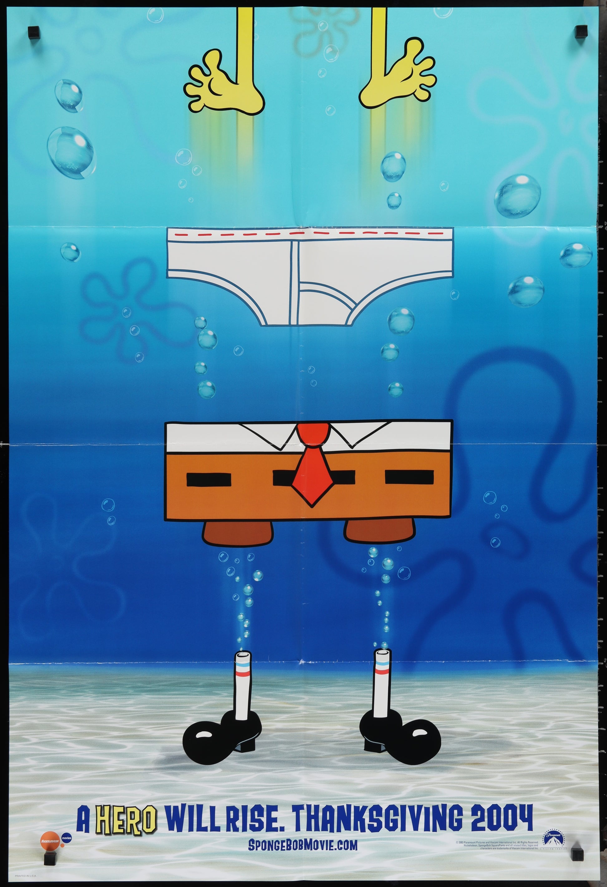 The image features a vibrant and colorful movie poster for the 2004 animated film "The SpongeBob SquarePants Movie." The poster depicts the iconic character SpongeBob SquarePants in a humorous and playful pose, with a backdrop of a blue ocean.