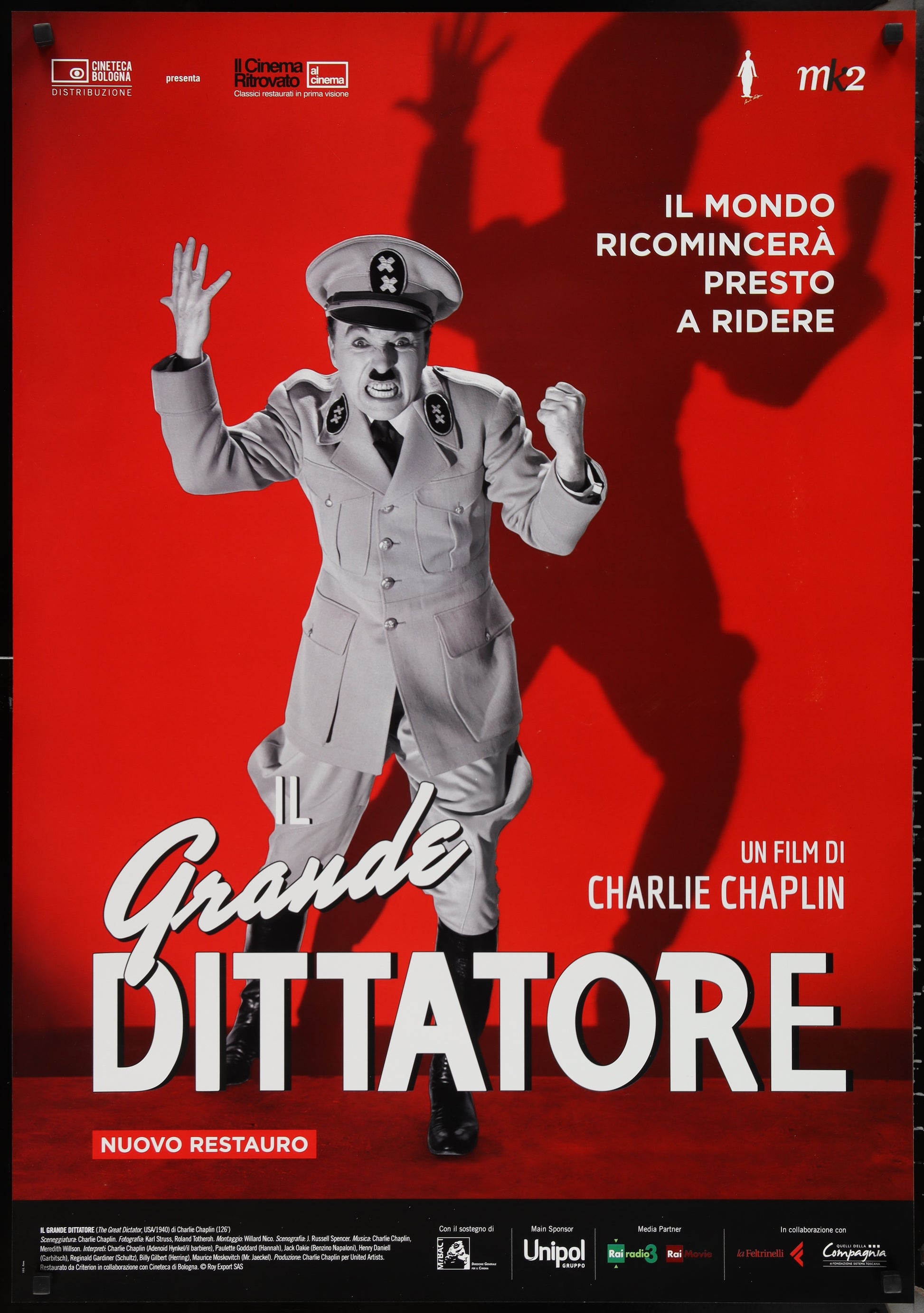 Theatrical re-release Italian one-sheet movie poster for 'The Great Dictator' featuring Charlie Chaplin, with red background and minimal edge wear.