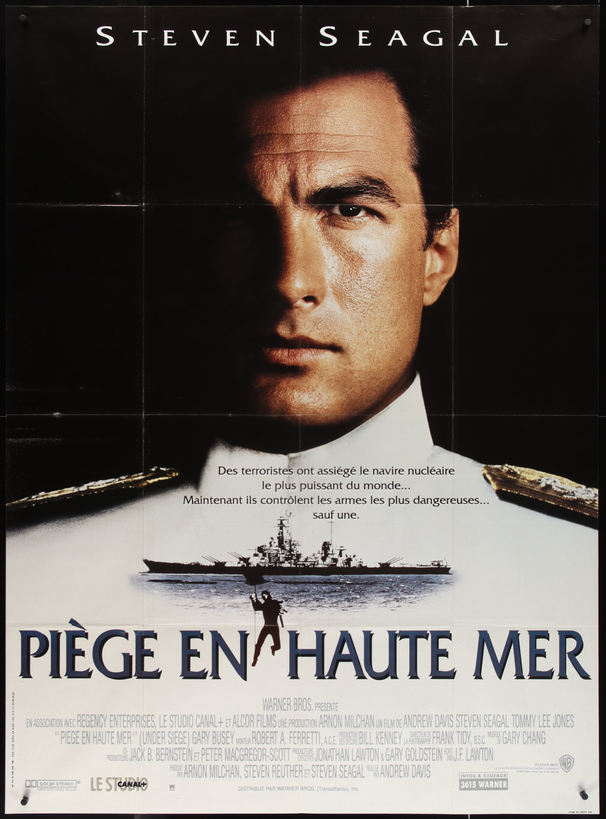 A vintage French one-panel movie poster for 'Under Siege' featuring a portrait of Steven Seagal in a military uniform, with a background showing a naval ship.