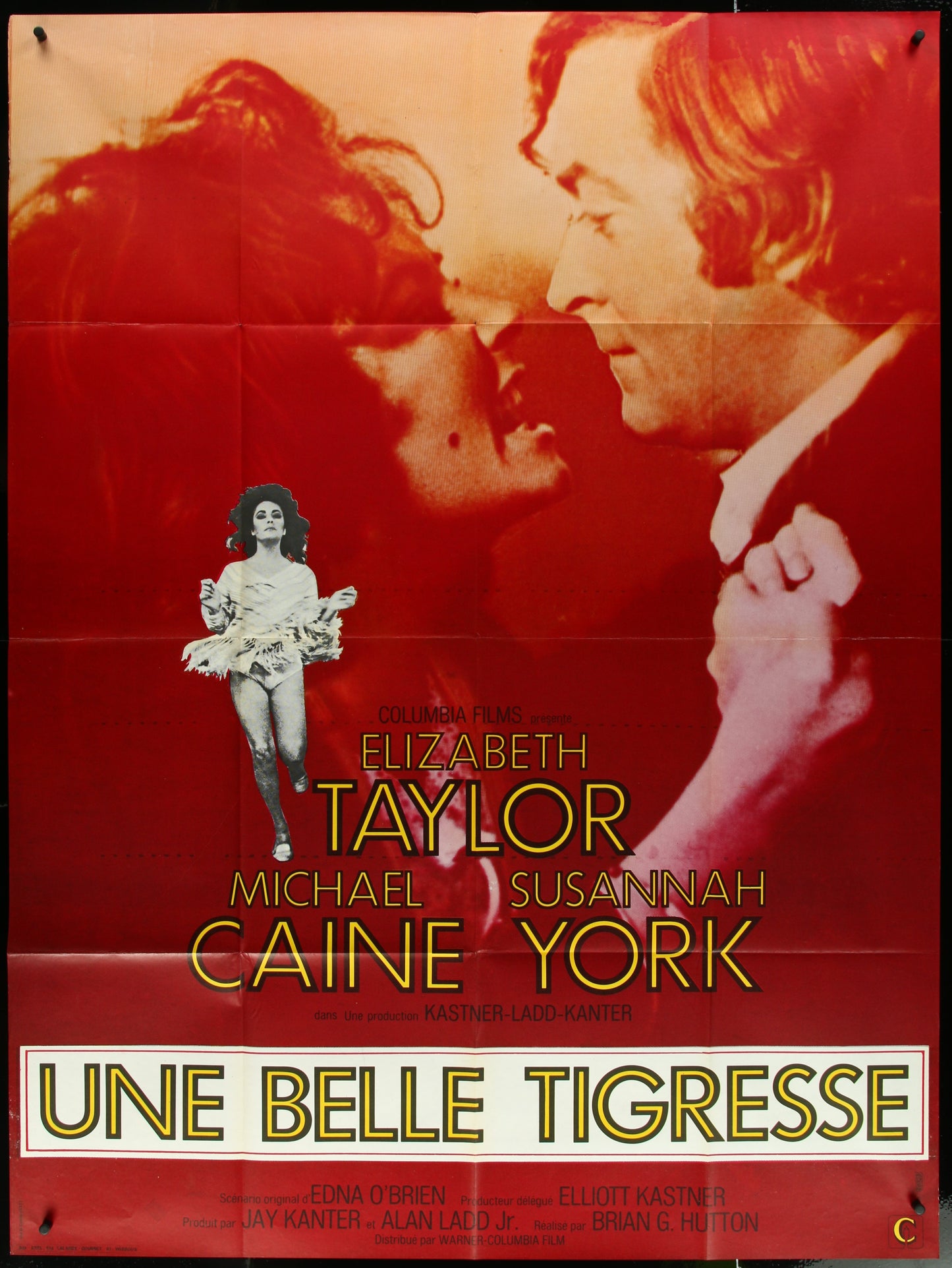 A vintage movie poster for 'X Y and Zee' featuring images of the actors Elizabeth Taylor and Michael Caine, with a red background and the title ' Une Belle Tigresse ' displayed.